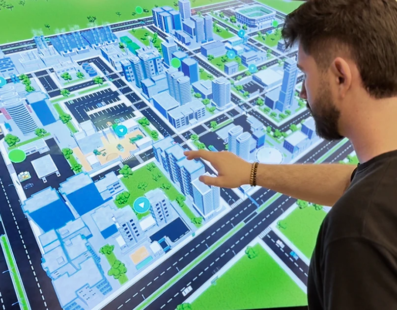 Person using the Intelbras Smart Cities 3D city on a touchscreen